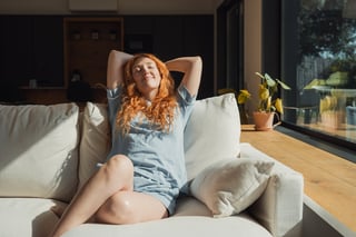 Woman relaxing on couch in sunlight